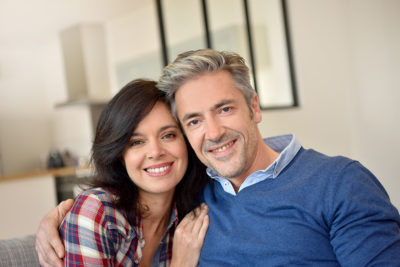 happy, healthy couple in their 40s in their living room